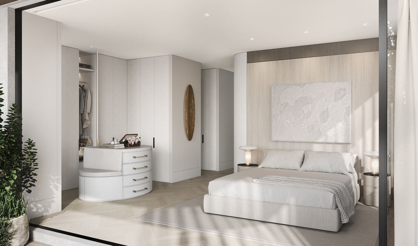 Primary bedroom with a curved dressing table, walk-in wardrobe, and an upholstered bed set against a timber feature wall.