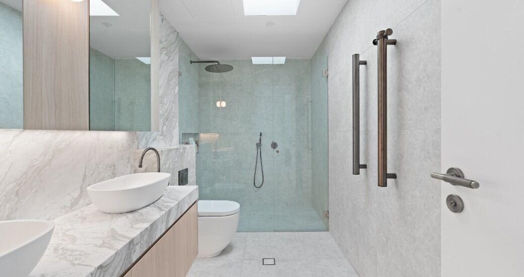 Bathroom with a frameless glass shower, floating oak vanity and marble benchtop.